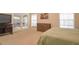 Bright main bedroom with doors to patio and neutral carpet, featuring a wood dresser and art at 200 Hummingbird Ln, Longwood, FL 32779