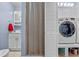 View of a bathroom with a vanity, shower stall and storage, adjacent to a washer and dryer in a utility area at 2190 Temple Dr, Winter Park, FL 32789