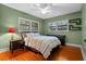 A bright bedroom features hardwood floors, two windows with blinds, a ceiling fan and a queen bed at 2190 Temple Dr, Winter Park, FL 32789