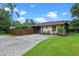 Property featuring a paved driveway, green lawn, and privacy fence, perfect for outdoor enjoyment at 2190 Temple Dr, Winter Park, FL 32789