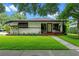 Inviting home showcasing a well-maintained lawn and an appealing facade with cozy front porch seating at 2190 Temple Dr, Winter Park, FL 32789