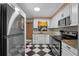 Modern kitchen with stainless steel appliances, a black and white checkered floor, and granite countertops at 2190 Temple Dr, Winter Park, FL 32789