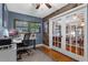 Home office with wood paneled accent wall, lots of light, and glass french doors at 2190 Temple Dr, Winter Park, FL 32789