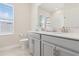 Bright bathroom with double vanity, grey cabinets, and a framed mirror at 2279 Mountain Pine St, Ocoee, FL 34761