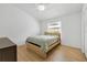 A bright bedroom featuring a queen bed, light wood flooring, and fresh, white paint at 2308 Donegan Pl, Orlando, FL 32826