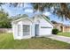 Charming single-story home with a white exterior, attached garage, and well-maintained lawn at 2308 Donegan Pl, Orlando, FL 32826