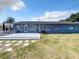 The backyard features a gray back wall of the home with bright blue skies at 249 Spartan Dr, Maitland, FL 32751