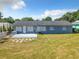 The backyard features a gray back wall of the home with bright blue skies at 249 Spartan Dr, Maitland, FL 32751