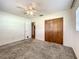 This bedroom features a ceiling fan, closet with wood doors and neutral carpeting at 249 Spartan Dr, Maitland, FL 32751