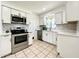 Modern kitchen with stainless steel oven and microwave, along with white cabinets and countertops at 249 Spartan Dr, Maitland, FL 32751
