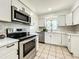 Bright kitchen features white cabinets, stainless steel appliances, and modern backsplash at 249 Spartan Dr, Maitland, FL 32751