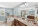 Elegant bathroom featuring a soaking tub, separate shower, and a large vanity with granite countertops at 25537 High Hampton Cir, Sorrento, FL 32776