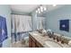 Charming bathroom with double sinks, granite countertop, and nautical themed shower curtain at 25537 High Hampton Cir, Sorrento, FL 32776