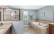 Elegant bathroom with a soaking tub, separate shower, and neutral tile, perfect for relaxation and comfort at 25537 High Hampton Cir, Sorrento, FL 32776