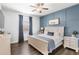 Cozy bedroom featuring modern decor, blue accent wall, and matching bedside tables and luxury vinyl plank flooring at 25537 High Hampton Cir, Sorrento, FL 32776