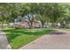 Beautiful home exterior with large trees and a brick driveway at 25537 High Hampton Cir, Sorrento, FL 32776