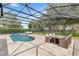 Stunning screened pool area with dining and lounge seating, providing a relaxing outdoor oasis at 25537 High Hampton Cir, Sorrento, FL 32776
