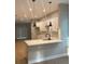 Modern kitchen featuring white cabinets, marble countertops, stainless steel appliances, and sleek pendant lighting at 317 Mandrake St, Orlando, FL 32811