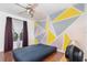 Cozy bedroom with geometric accent wall and modern ceiling fan at 32125 Wekiva Pines Blvd, Sorrento, FL 32776