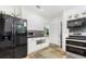 Bright kitchen with black appliances, granite countertops, white cabinets and decorative mosaic backsplash at 32125 Wekiva Pines Blvd, Sorrento, FL 32776