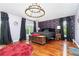 View of the spacious bedroom featuring hardwood floors, modern chandelier, and large windows at 32125 Wekiva Pines Blvd, Sorrento, FL 32776