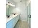 Elegant bathroom featuring double sinks, modern fixtures, and a glass-enclosed shower at 341 Switchgrass Loop, Minneola, FL 34715
