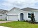 Charming single-story home with a two-car garage, manicured lawn, and tasteful landscaping at 341 Switchgrass Loop, Minneola, FL 34715