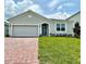 Lovely single-story home with brick paver driveway, arched entry and well-maintained lawn at 341 Switchgrass Loop, Minneola, FL 34715