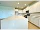Modern kitchen with a large island, stainless steel appliances, and white cabinetry at 341 Switchgrass Loop, Minneola, FL 34715