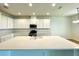 Spacious kitchen features a large center island, modern appliances, and ample white cabinetry at 341 Switchgrass Loop, Minneola, FL 34715