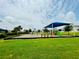 Community playground featuring a slide and swings, set on a lush green lawn at 341 Switchgrass Loop, Minneola, FL 34715