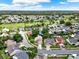 Overhead perspective of homes in a verdant neighborhood adjacent to a golf course under a sunny sky at 3561 Ventura Club Cir, Orlando, FL 32822