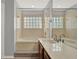 Bright bathroom featuring a bathtub, shower, and dual sink vanity with a large mirror at 3561 Ventura Club Cir, Orlando, FL 32822