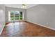 Bright bedroom with hardwood floors, ceiling fan, and large window overlooking the lawn at 3561 Ventura Club Cir, Orlando, FL 32822
