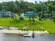 Waterfront property featuring a charming home, private beach, boat dock, and lush greenery at 36607 E Eldorado Lake Dr, Eustis, FL 32736