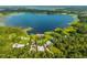 Aerial view outlining a lakefront property with mature trees and beautiful landscaping at 36607 E Eldorado Lake Dr, Eustis, FL 32736