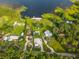 Aerial view showcasing a lakefront home surrounded by lush greenery and a private dock at 36607 E Eldorado Lake Dr, Eustis, FL 32736
