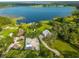 Picturesque aerial view of a lakefront estate with a sprawling lawn and mature trees at 36607 E Eldorado Lake Dr, Eustis, FL 32736