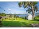 Expansive lawn leading to lake frontage, with a storage shed nestled in the landscape at 36607 E Eldorado Lake Dr, Eustis, FL 32736