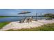 Relaxing lakeside beach area with umbrellas, lounge chairs, and clear water views at 36607 E Eldorado Lake Dr, Eustis, FL 32736