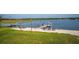 Lakefront property with a private sandy beach area, dock, and serene water views at 36607 E Eldorado Lake Dr, Eustis, FL 32736
