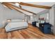 Bright bedroom featuring exposed beams, wood floors, sitting area, and a comfortable king bed at 36607 E Eldorado Lake Dr, Eustis, FL 32736