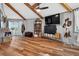 Open bedroom with wood floors, TV, exposed wood beam ceiling and shelves at 36607 E Eldorado Lake Dr, Eustis, FL 32736