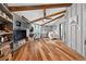 Open bedroom with wood floors, TV, exposed wood beam ceiling, desk and closet at 36607 E Eldorado Lake Dr, Eustis, FL 32736