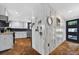 Entryway with a view into the modern kitchen, black door, and stone flooring at 36607 E Eldorado Lake Dr, Eustis, FL 32736