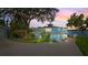 Stunning two-story home with a white railing balcony, and lakeside at sunset at 36607 E Eldorado Lake Dr, Eustis, FL 32736
