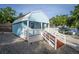 Adorable blue cottage with white trim, a cozy porch, and a gravel yard at 36607 E Eldorado Lake Dr, Eustis, FL 32736