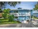 Bright blue two-story home with white trim, a balcony, and lush landscaping in the front yard at 36607 E Eldorado Lake Dr, Eustis, FL 32736