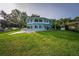 Blue two-story home with manicured lawn, gazebo, and landscaping at 36607 E Eldorado Lake Dr, Eustis, FL 32736