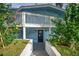 A blue house with stairs leading to the second story and flowering bushes at 36607 E Eldorado Lake Dr, Eustis, FL 32736